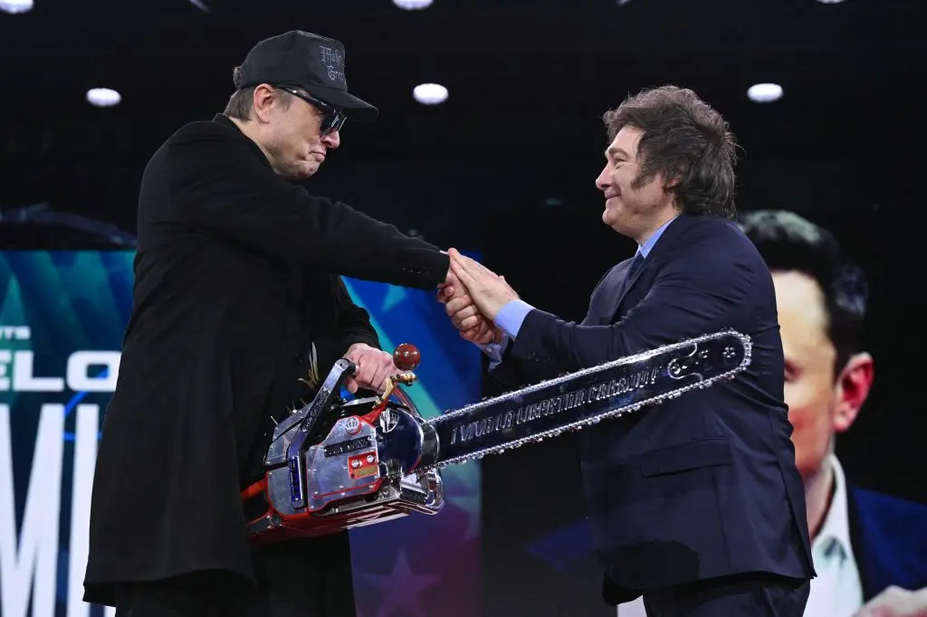 Elon Musk sostiene una motosierra mientras estrecha la mano del presidente argentino Javier Milei en la Conferencia de Acción Política Conservadora en Oxon Hill, Maryland, el 20 de febrero de 2025.